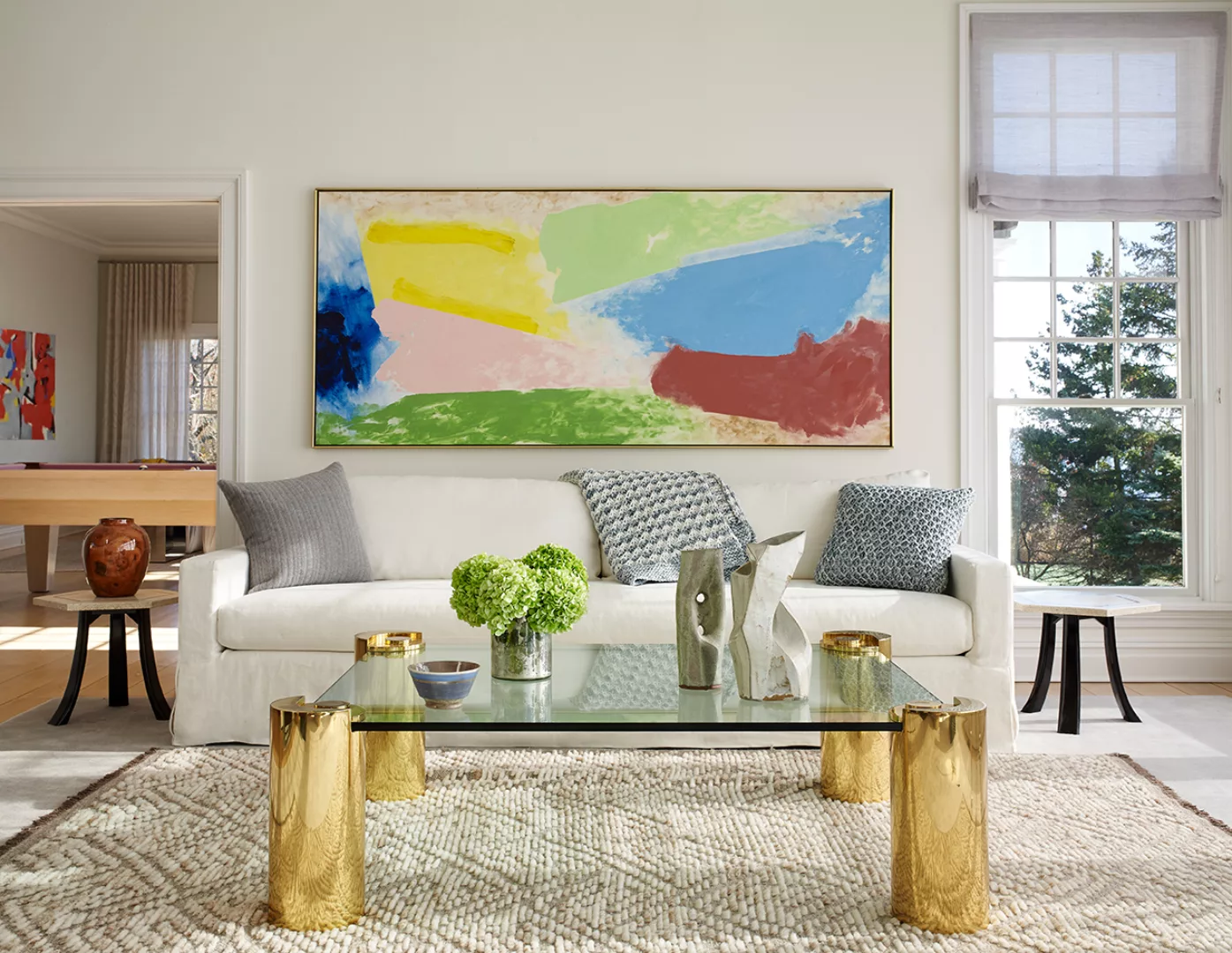 White Tux Sofa, a Crystal table with Golden Legs, and A Big Abstract Painting