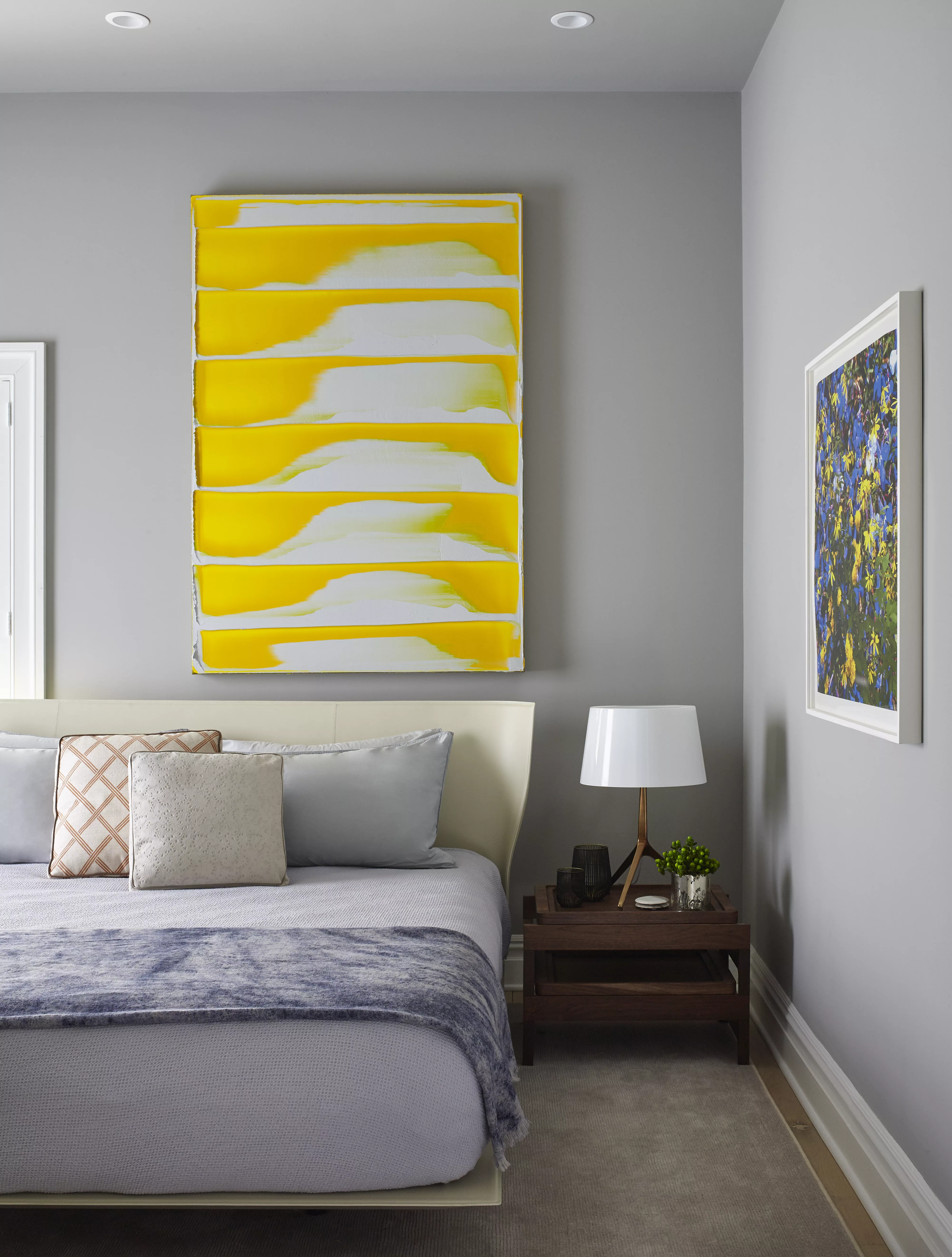 Bedroom detail with bright yellow abstract painting