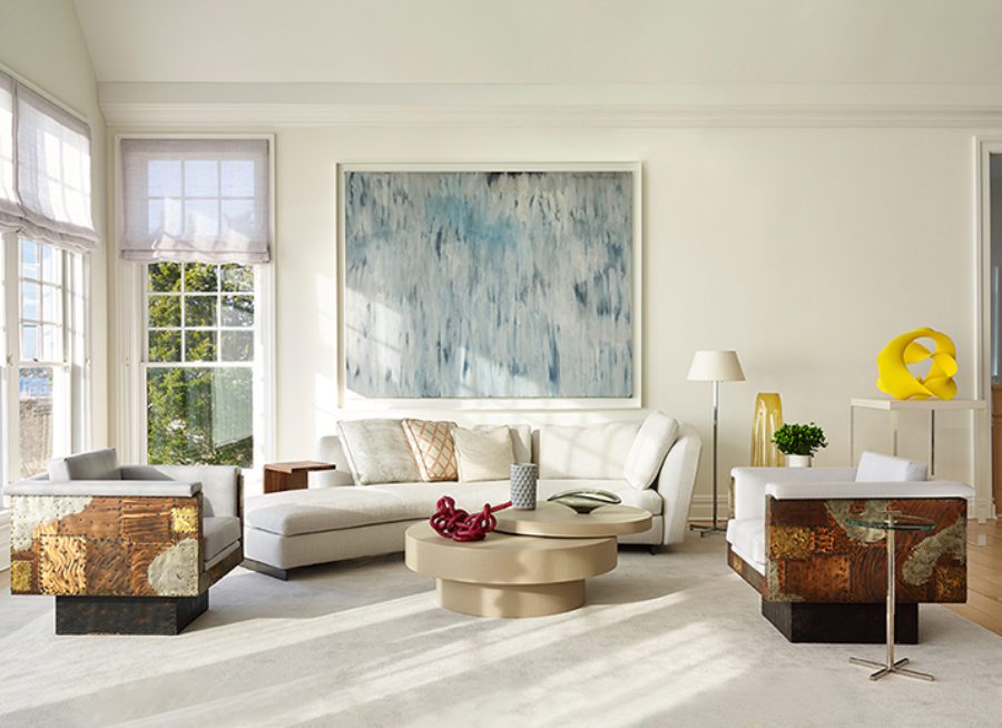 Living Room with A White Tux Sofa, Two Comfortable Armchairs and a Small Beige Round Table