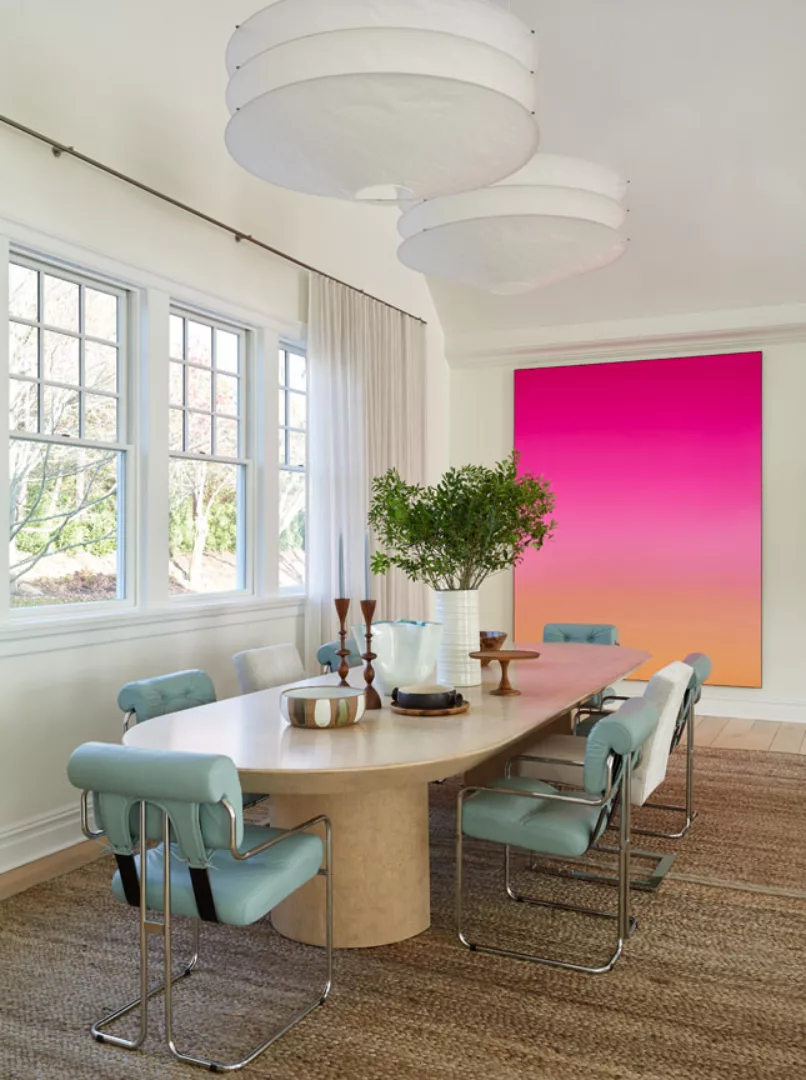 Dining room with bright abstract pink painting and blue dining chairs